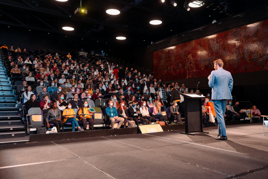 Speaker addressing crowded auditorium at EAGxAustralia 2022 conference